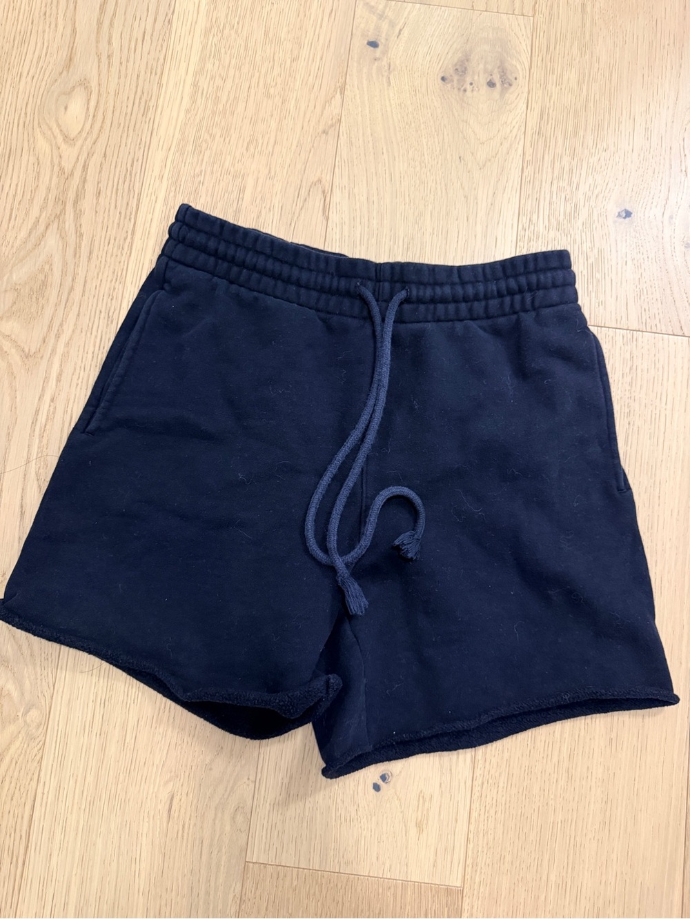 Black TNA sweat shorts with raw hem and elastic waistband